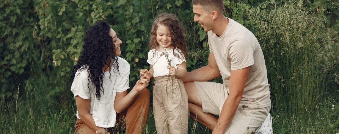 A joyful family enjoying time together in a lush green field.